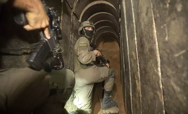 Israeli soldiers escort the media to a tunnel found underneath Shifa Hospital in Gaza City, Wednesday, Nov. 22, 2023. Israel says that Hamas militants sought cover on the grounds of the hospital and used the tunnel for military purposes. (AP Photo/Victor R. Caivano)