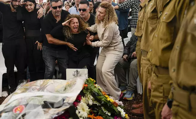 Sivan, the mother of Israeli soldier Sgt. Dolev Malca, screams as she salutes her son during his funeral in Shlomi, northern Israel, on the border with Lebanon, Sunday, March 3, 2024. (AP Photo/Ariel Schalit)