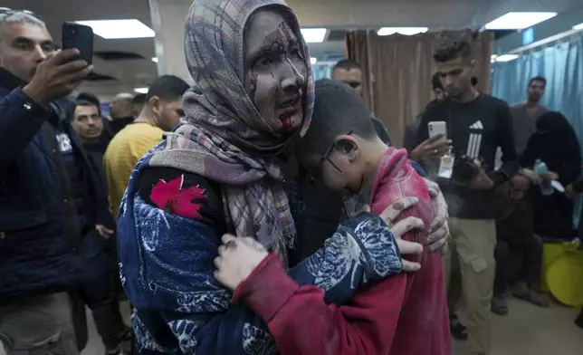 Palestinians wounded in the Israeli bombardment of the Gaza Strip are brought to the hospital in Deir al Balah on Friday, Dec. 8, 2023. (AP Photo/Adel Hana)