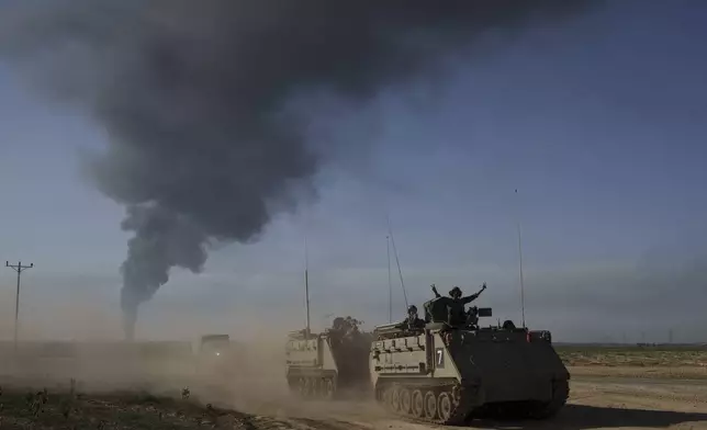 Israeli soldiers move on armored personnel carriers (APC) near the Israeli-Gaza border as smoke rises to the sky in the Gaza Strip, seen from southern Israel, Sunday, Jan. 21, 2024. (AP Photo/Leo Correa)