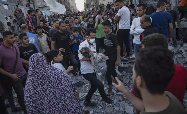 A child is carried from the rubble of a building after an airstrike in Khan Younis, Gaza Strip, Saturday, Oct. 21, 2023. (AP Photo/Fatima Shbair)