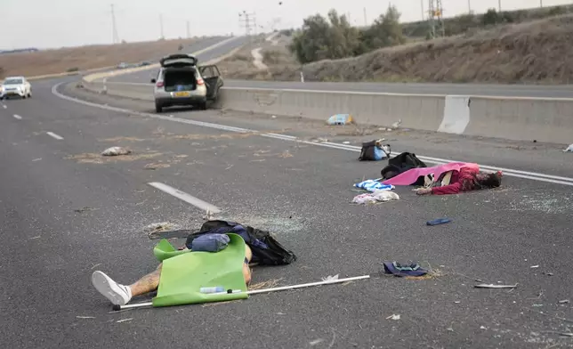 Israelis killed by Hamas militants lie on the road near Sderot, Israel, on Oct. 7, 2023. (AP Photo/Ohad Zwigenberg)