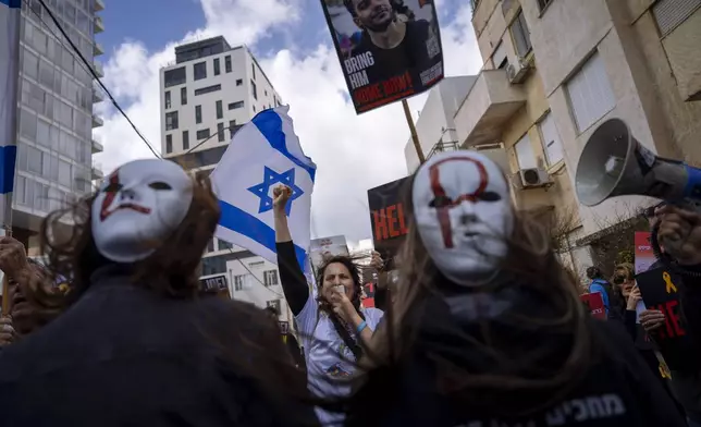 Families and supporters of Israeli hostages held by Hamas in Gaza wave photos of their loved ones and the Israeli and U.S. flags during a protest calling for their return, outside a meeting between U.S. Secretary of State Antony Blinken and families of hostages, in Tel Aviv, Israel, Friday, March 22, 2024. (AP Photo/Oded Balilty)