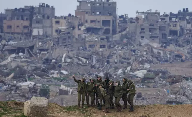 Israeli female soldiers pose for a photo on a position on the Gaza Strip border, in southern Israel, Monday, Feb. 19, 2024. (AP Photo/Tsafrir Abayov)