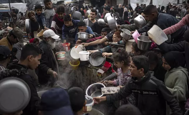 Palestinians line up for a meal in Rafah, Gaza Strip, Thursday, Dec. 21, 2023. (AP Photo/Fatima Shbair)