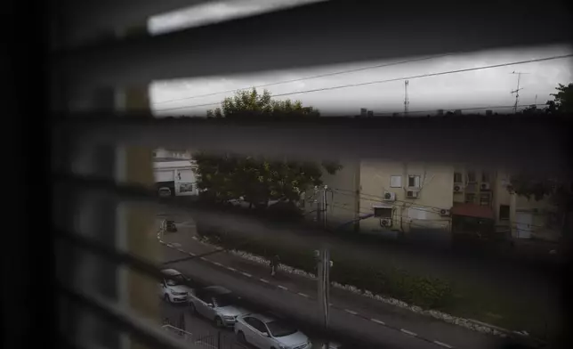 A member of the Israeli forces walks down a street near where a police station was destroyed during the Hamas attack on Oct. 7, 2023, as seen from the bedroom window of Lilach Almog's apartment in Sderot, Israel, Sunday, Sept. 22, 2024. (AP Photo/Leo Correa)