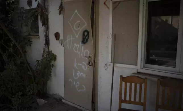 The front door of the home of Shlomo Margalit and Hanna’le Margalit that was damaged by Hamas militants during their attack on Oct. 7, 2023, is seen at Kibbutz Nir Oz, Israel, Thursday, Sept. 26, 2024. (AP Photo/Leo Correa)