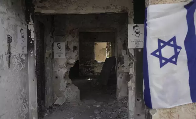 An Israeli flag is hung on a destroyed house nearly a year after the deadly Hamas attack on Oct. 7, in Kibbutz Kfar Aza, Israel, Monday, Sept. 16, 2024. (AP Photo/Ohad Zwigenberg)