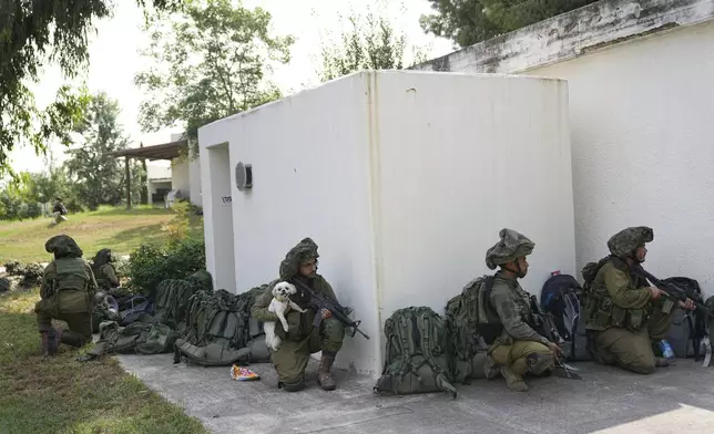 FILE- Israeli soldiers deploy in Kibbutz Kfar Aza on Tuesday, Oct. 10, 2023. (AP Photo/Ohad Zwigenberg, File)