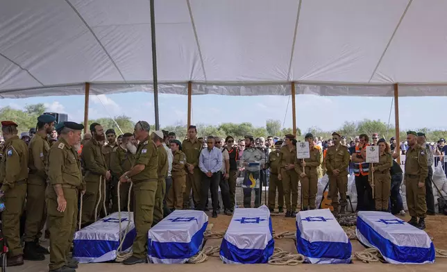 FILE- Mourners gather around the five coffins of the Kotz family during their funeral in Gan Yavne, Israel, Tuesday, Oct. 17, 2023. The family was killed by Hamas militants on Oct. 7 at their house in Kibbutz Kfar Aza near the border with the Gaza Strip,. (AP Photo/Ohad Zwigenberg, File)