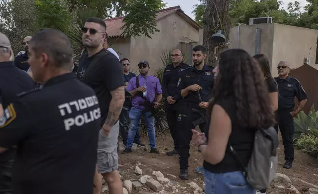 Israeli police officers guard a tour of visitors viewing the damage wrought by the Oct. 7 Hamas onslaught on Kibbutz Kfar Aza, southern Israel, Monday, Sept. 16, 2024. (AP Photo/Ohad Zwigenberg