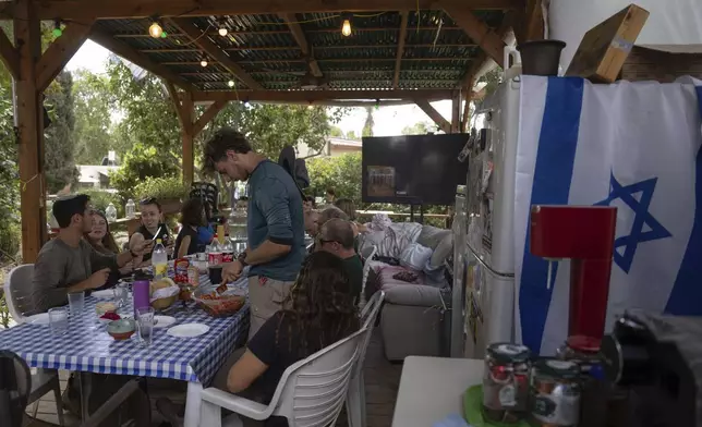 Residents who live in the near-empty kibbutz of Kfar Aza almost a year after the deadly Hamas onslaught eat lunch together in the community in southern Israel, Monday, Sept. 16, 2024. (AP Photo/Ohad Zwigenberg)