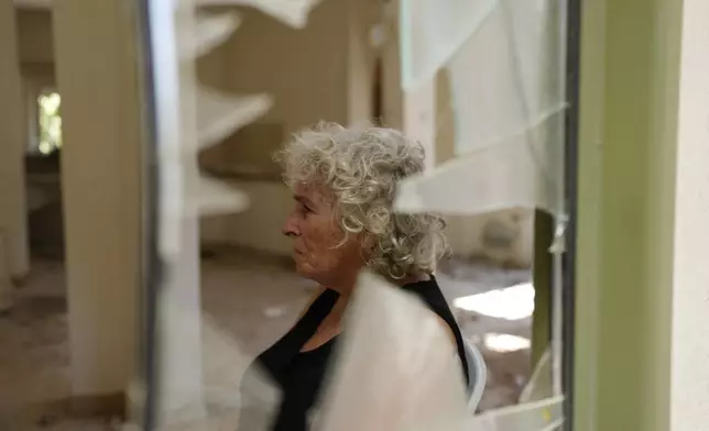 Liora Eilon, whose son, Tal Eilon, was killed by Hamas militants on Oct. 7, poses in her blasted-out home with her daughter Hadas Eilon-Carmi, left, in Kibbutz Kfar Aza, southern Israel, Sunday, Aug. 18, 2024. (AP Photo/Ohad Zwigenberg)