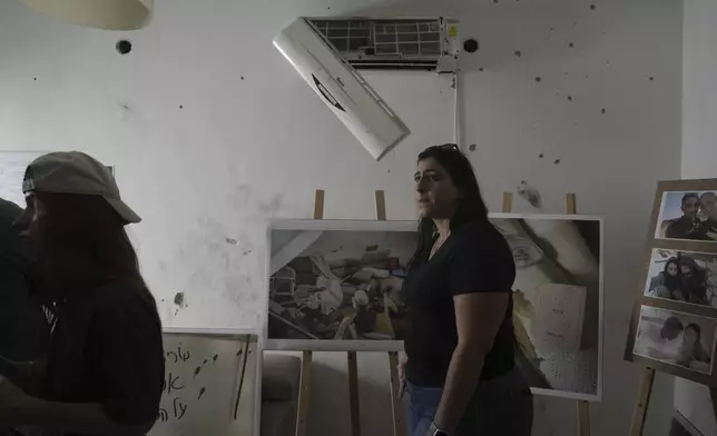 Visitors tour a bullet-ridden house in Kibbutz Kfar Aza a year after Hamas militants attacked the border community in southern Israel, Monday, Sept. 16, 2024. (AP Photo/Ohad Zwigenberg)