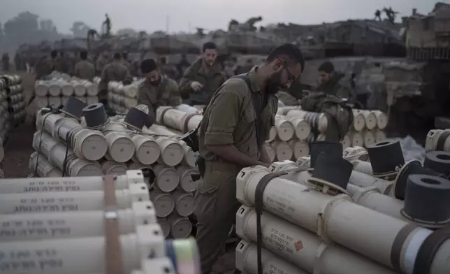 FILE - Israeli soldiers from the artillery unit store tank shells in a staging area at the Israeli-Gaza border in southern Israel, on Jan. 1, 2024. (AP Photo/Leo Correa, File)