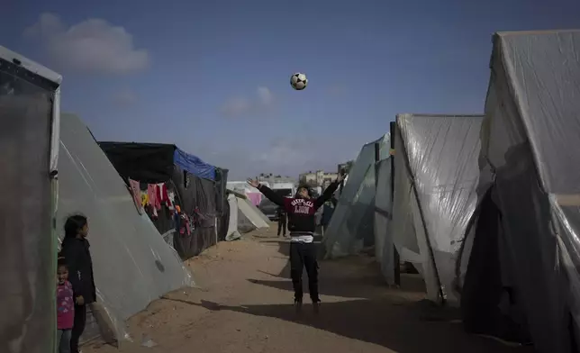 FILE - Palestinians displaced by the Israeli ground offensive on the Gaza Strip play at the makeshift tent camp in Rafah on Tuesday, Jan. 23, 2024. (AP Photo/Fatima Shbair, File)