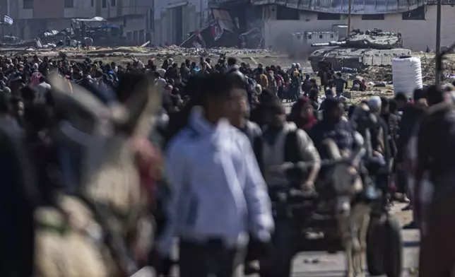 FILE - An Israeli army tank takes up position as Palestinians arrive in the southern Gaza town of Rafah after fleeing an Israeli ground and air offensive in the nearby city of Khan Younis on Friday, Jan. 26, 2024. (AP Photo/Fatima Shbair, File)