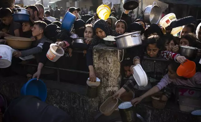 FILE - Palestinians line up for a free meal in Rafah, Gaza Strip, on Tuesday, March 12, 2024. (AP Photo/Fatima Shbair, File)