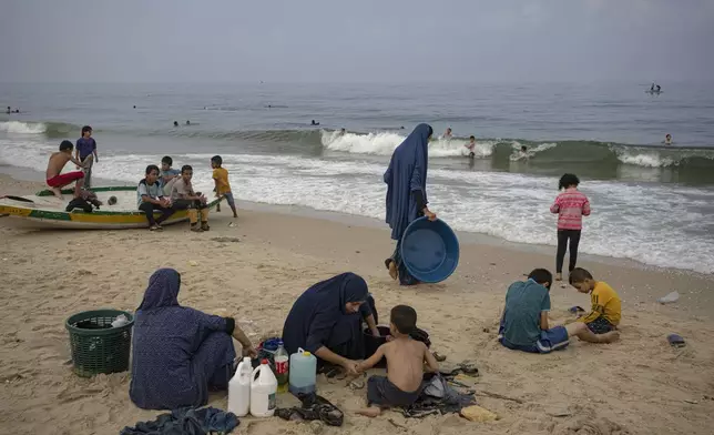 FILE - Palestinian women wash clothes with seawater at the beach in Deir al Balah, Gaza Strip, Thursday, Nov. 2, 2023. (AP Photo/Fatima Shbair, File)