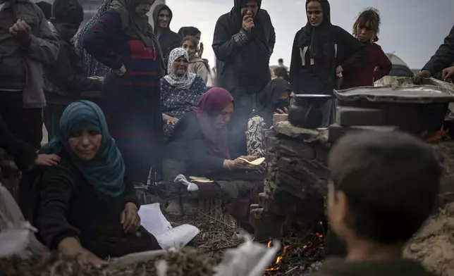 FILE - Palestinians displaced by the Israeli bombardment wait for their turn to bake bread at the makeshift tent camp in the Muwasi area in Rafah, Gaza Strip, Saturday, Dec. 23, 2023. (AP Photo/Fatima Shbair, File)