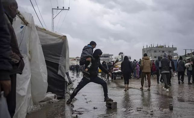 FILE - Palestinians displaced by the Israeli air and ground offensive on the Gaza Strip walk through a makeshift tent camp in Rafah on Saturday, Jan. 27, 2024. (AP Photo/Fatima Shbair, File)