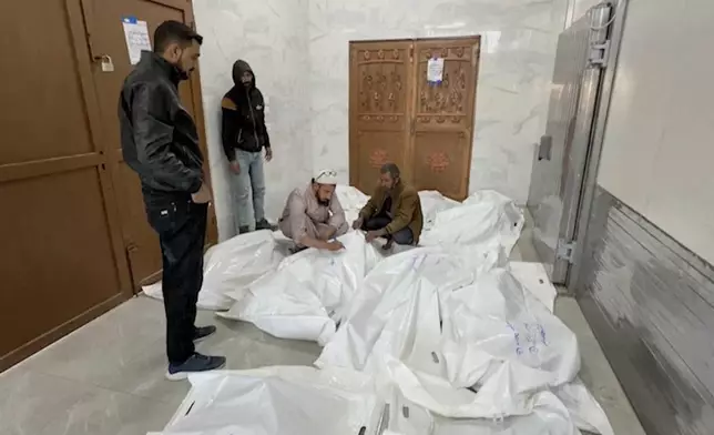 Palestinians gather in a morgue with the bodies of their relatives killed in Israeli airstrikes in the city of Khan Younis, southern Gaza Strip, Friday, Oct. 25, 2024. (AP Photo)