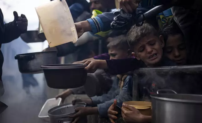 FILE - Palestinians line up for a meal in Rafah, Gaza Strip, Friday, Feb. 16, 2024. (AP Photo/Fatima Shbair, File)