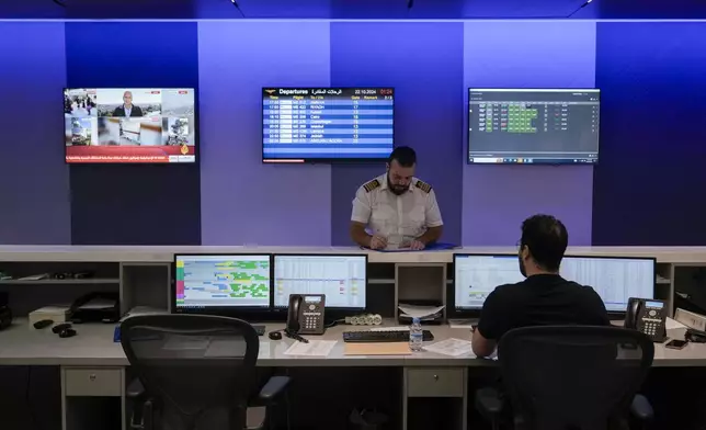 Middle East Airlines employees work in the operations room at the MEA offices in Beirut, Tuesday, Oct. 22, 2024. (AP Photo/Bilal Hussein)