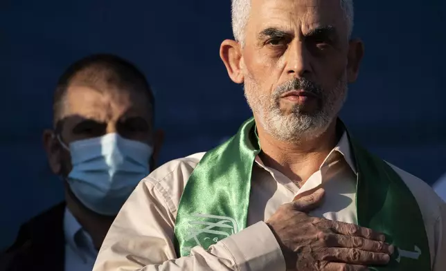 FILE - Yahya Sinwar, Palestinian leader of Hamas in the Gaza Strip, places his hand over his heart on stage after greeting supporters at a rally on May 24, 2021, in Gaza City, the Gaza Strip. (AP Photo/John Minchillo, File)