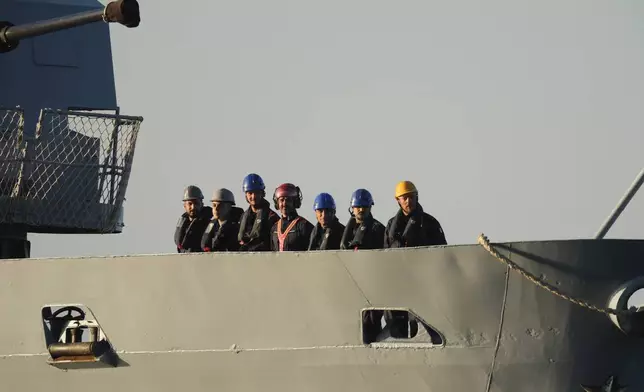 Security official stands on the Italian navy ship Libra as it arrives at the port of Shengjin, northwestern Albania Wednesday, Oct. 16, 2024, carrying the first group of migrants who were intercepted in international waters. (AP Photo/Vlasov Sulaj)