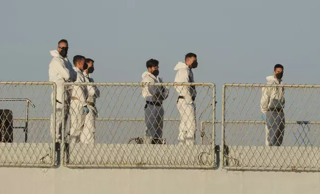 Security official stand on the Italian navy ship Libra as it arrives at the port of Shengjin, northwestern Albania Wednesday, Oct. 16, 2024, carrying the first group of migrants who were intercepted in international waters. (AP Photo/Vlasov Sulaj)