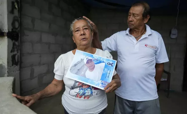 Adelaida Mero, accompanied by her husband Carlos, holds a picture of her grandson Jesus during an interview at their home in San Mateo, Ecuador, Wednesday, Sept. 25, 2024. Mero said her grandson was killed while working as a fisherman. (AP Photo/Dolores Ochoa)