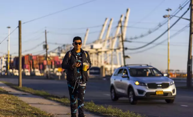 Ecuadorian Anthony Angulo walks to work in Bayonne, New Jersey, Tuesday, Oct. 22, 2024. (AP Photo/Eduardo Munoz Alvarez)