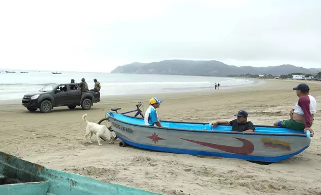 Soldiers patrol the beach where fishermen rest inside their boat in Puerto Lopez, Ecuador, Tuesday, Sept. 24, 2024. (AP Photo/Dolores Ochoa)