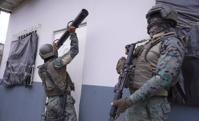 FILE - A soldier uses a battering ram to bust open a door during a joint operation with police in search of weapons and drugs, in a neighborhood of Guayaquil, Ecuador, Oct. 16, 2024. (AP Photo/Cesar Munoz, File)