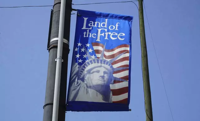 A patriotic banner hangs from a utility pole in downtown Mount Olive, N.C., on Monday, July 15, 2024. (AP Photo/Allen G. Breed)