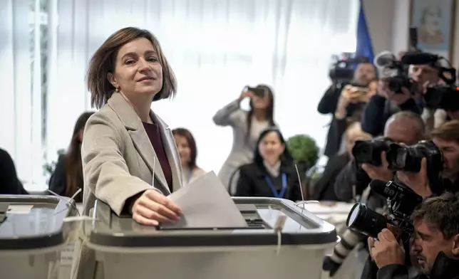 Moldova's President Maia Sandu prepares to cast her vote, in Chisinau, Moldova, Sunday, Oct. 20, 2024, during a presidential election and a referendum on whether to enshrine in the Constitution the country's path to European Union membership. (AP Photo/Vadim Ghirda)