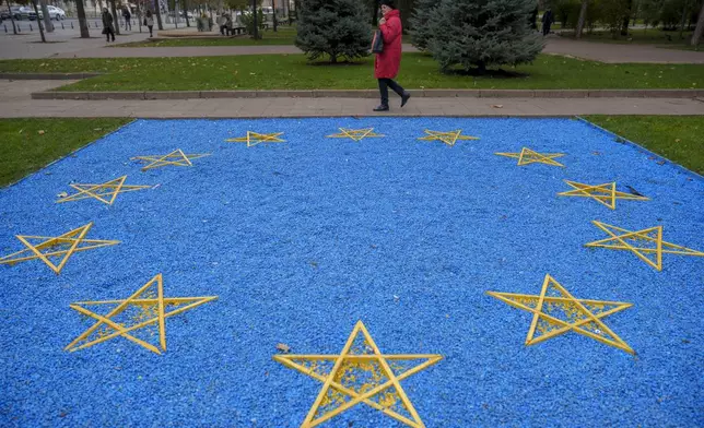 A woman walks by an European Union flag made of blue pebbles in Chisinau, Moldova, Thursday, Oct. 17, 2024, ahead of a presidential election and a referendum of whether to enshrine in Moldova's Constitution its path to European Union membership taking place on Oct.20. (AP Photo/Vadim Ghirda)