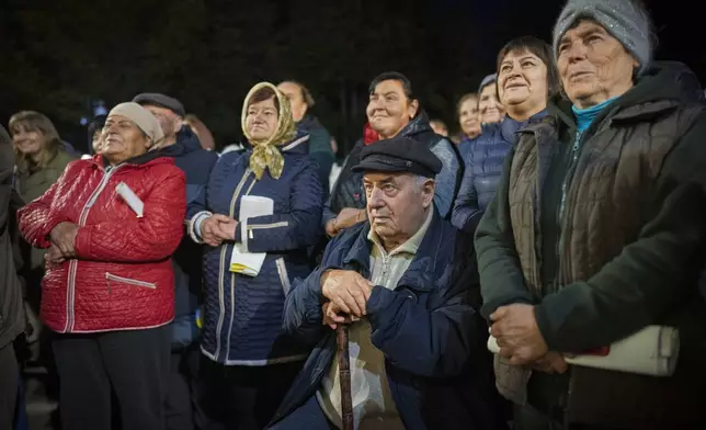 People listen to Moldova's President Maia Sandu speaking in Magdacesti, Moldova, Thursday, Oct. 17, 2024, as she seeks a second term in office ahead of a presidential election and a referendum of whether to enshrine in Moldova's Constitution its path to European Union membership taking place on Oct.20. (AP Photo/Vadim Ghirda)