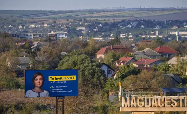 A poster of Moldova's President Maia Sandu that reads "I invite you to vote" is placed on the side of the road in Magdacesti, Moldova, Thursday, Oct. 17, 2024, ahead of a presidential election and a referendum of whether to enshrine in Moldova's Constitution its path to European Union membership taking place on Oct.20. (AP Photo/Vadim Ghirda)