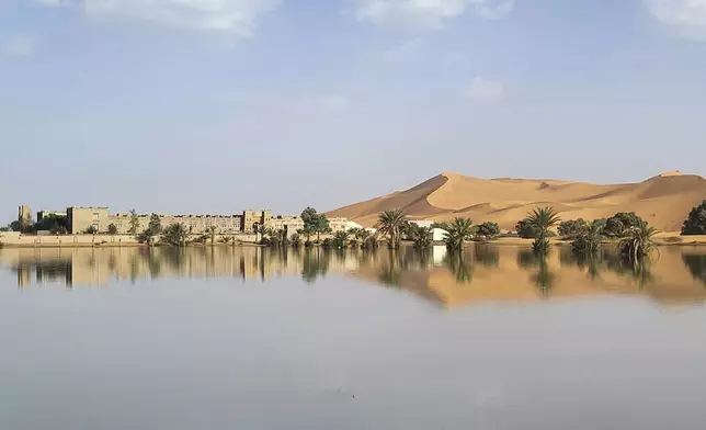 An oasis is reflected in a lake caused by heavy rainfall in the desert town of Merzouga, near Rachidia, southeastern Morocco, Wednesday, Oct. 2, 2024. (AP Photo)