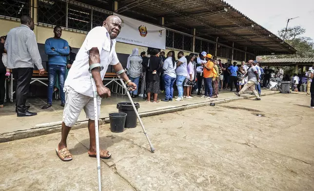 People queue to cast their votes at a polling station in general elections in Maputo, Mozambique, Wednesday, Oct. 9, 2024. (AP Photo/Carlos Equeio)