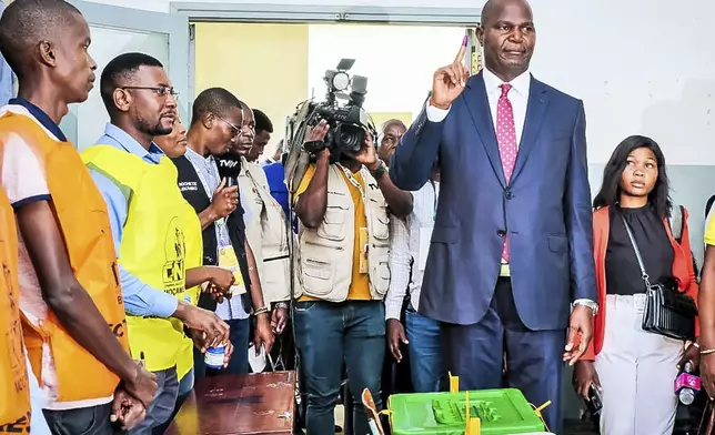 Daniel Chapo, right, presidential candidate for the ruling Front for the Liberation of Mozambique party, holds up his finger after casting his vote in the general elections, in Inhambane, Mozambique, Wednesday, Oct. 9, 2024. (AP Photo)