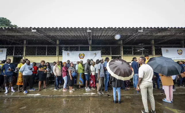 People queue to cast their votes at a polling station in general elections in Maputo, Mozambique, Wednesday, Oct. 9, 2024. (AP Photo/Carlos Equeio)