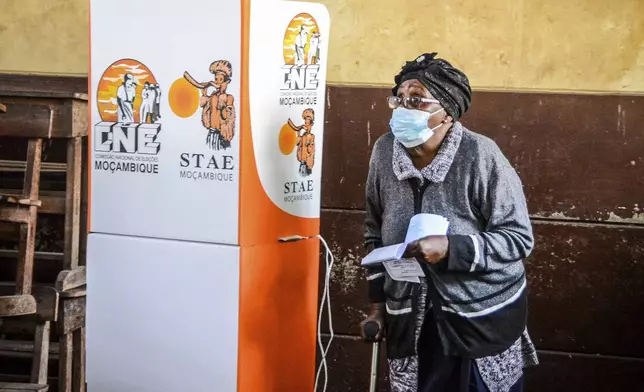 A woman walks out of a polling booth to cast her vote in general elections in Maputo, Mozambique, Wednesday, Oct. 9, 2024. (AP Photo/Carlos Equeio)