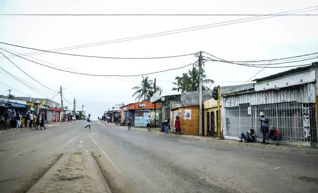 A lone man crosses the empty streets of Maputo, Mozambique, Monday, Oct. 21, 2024, during a nationwide shutdown protest following a disputed Oct. 9 election. (AP Photo/Carlos Uqueio)