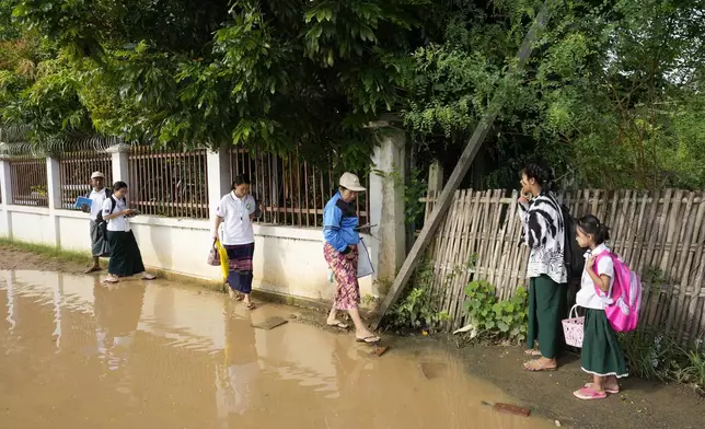 Myanmar census enumerators walk toward a neighborhood in Naypyitaw, Myanmar Tuesday, Oct. 1, 2024 as the country holds a national census to compile voter lists for a general election and to analyze population and socioeconomic trends. (AP Photo/Aung Shine Oo)