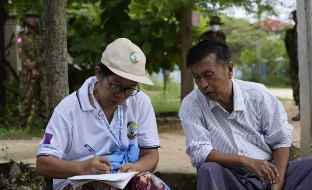 A census enumerator, left, asks questions to a man in Naypyitaw, Myanmar Tuesday, Oct. 1, 2024 as the country holds a national census to compile voter lists for a general election and to analyze population and socioeconomic trends. (AP Photo/Aung Shine Oo)