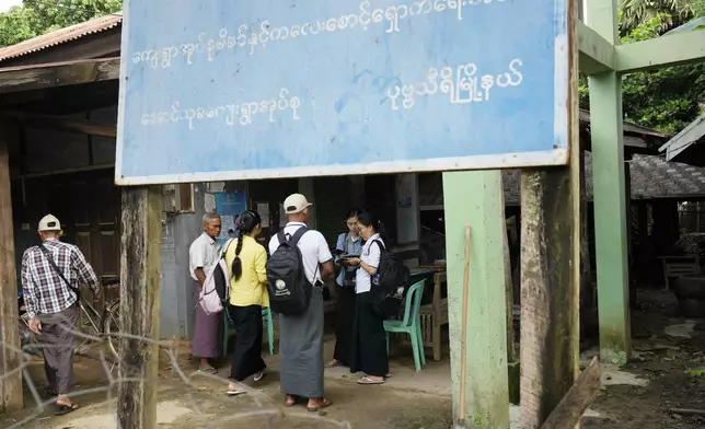 Census enumerators prepare to collect information from public in Naypyitaw, Myanmar Tuesday, Oct. 1, 2024 as the country holds a national census to compile voter lists for a general election and to analyze population and socioeconomic trends. A sign at an administration office reads " Village maternal and children care association." (AP Photo/Aung Shine Oo)