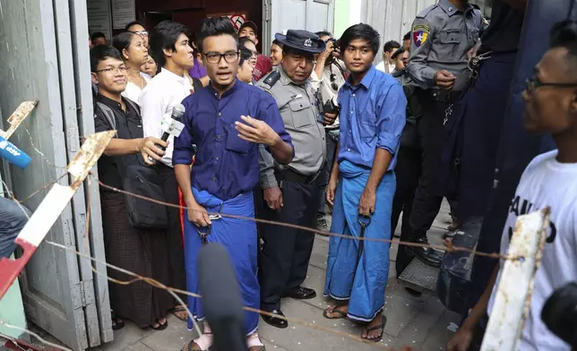 FILE - Paing Phyo Min, member of Student Union and a leader of Peacock Generation "Thangyat" Performance Group, talks to journalists as he leaves a township court along with his colleague, Zayar Lwin, right, after their trial, in Yangon, Myanmar, April 27, 2019. (AP Photo/Thein Zaw, File)